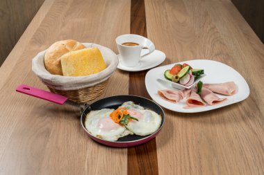 Tahta bir masada doyurucu bir kahvaltı: yumurtalı ekmek salatası ve kahve lezzetli bir yemek sağlar