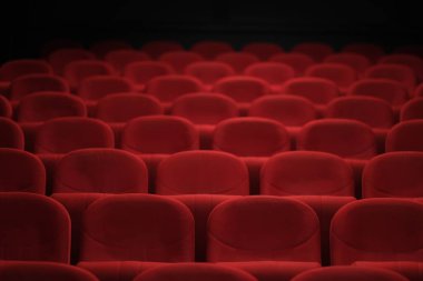 Konforlu kırmızı koltuklar, karanlık bir oditoryumda katılımcıları bekliyor. Beklenti içinde rahatlama sunuyorlar.