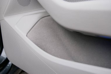 Solunda hoparlör olan bir araç kapısını ve gri keçeli kalemle kaplı açık bir depoyu kapat. Kapı beyaz plastik..