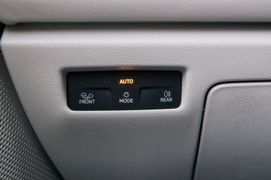 Yakın çekim, otomatikman far modu, ön ışıklar, arka ışıklar ve diğer ışık modu ayarları dahil olmak üzere, bir arabada otomatik ışıklandırma kontrollerini gösterir.