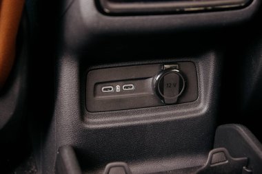 Yakın plan bir iç çekim iki USB-C port ve 12V priz gösteriyor, modern araç şarj ve bağlantı seçeneklerini vurguluyor.