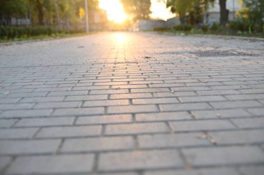 Kaldırım üzerindeki batan güneşin yansıması.