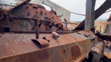 Paslı ve kırık piyade savaş aracı Ukrayna 'daki savaş sırasında topçu mermilerince yok edilen bir evde duruyor.