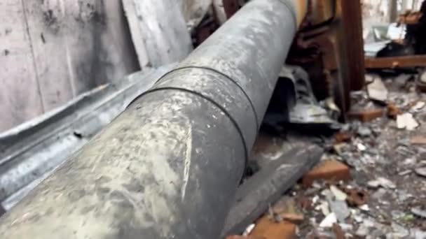 ウクライナでの戦争中に砲弾によって破壊されたウクライナの民家に隠された爆発で引き裂かれた砲塔を持つ錆びた壊れたロシアの戦車 — ストック動画