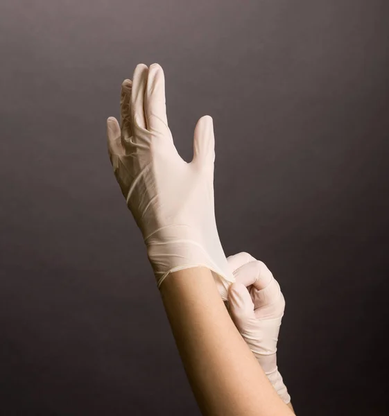 Mãos Femininas Colocando Luvas Látex Branco Fundo Escuro — Fotografia de Stock