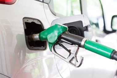 Yakıt pompasının hortumunu arabanın benzin deposuna kapatın. Benzin istasyonundaki depoya benzin pompalıyor..