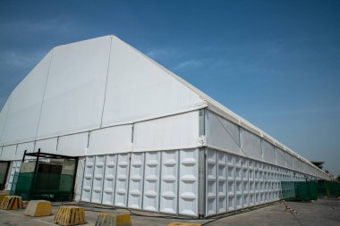Güneşli gökyüzünün altındaki çimenlik alanda büyük bir çadır.