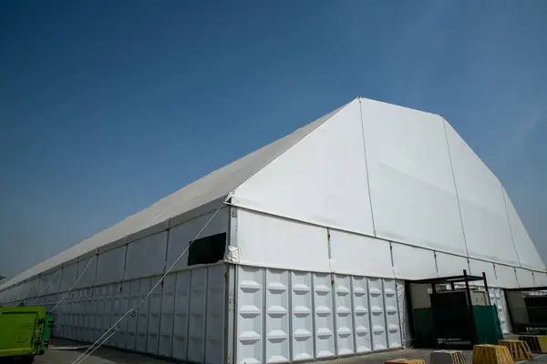 Güneşli gökyüzünün altındaki çimenlik alanda büyük bir çadır.