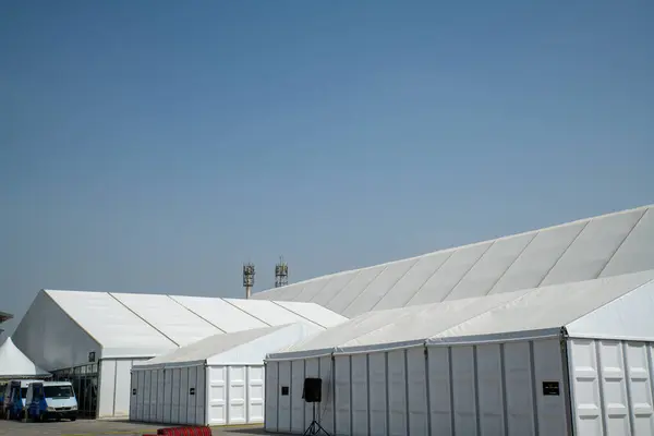 Güneşli gökyüzünün altındaki çimenlik alanda büyük bir çadır.