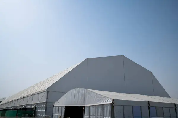 Güneşli gökyüzünün altındaki çimenlik alanda büyük bir çadır.