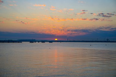 Doha Katar: Suyun üzerinde gün doğumu Eski Doha limanından manzara, güzel bir turuncu ve pembe gökyüzü yaratıyor