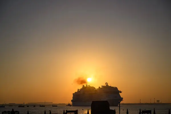 Doha Katar: Suyun üzerinde gün doğumu Eski Doha limanından manzara, güzel bir turuncu ve pembe gökyüzü yaratıyor