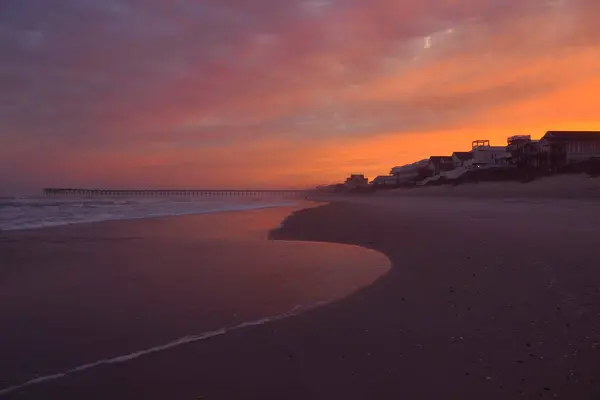 Kuzey Carolina plajı boyunca sahil evlerinin üzerinde gün batımı