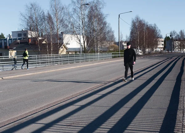 Man Walking Long Shadows Bridge Railing Bright Spring Sun Creates — Stock Photo, Image