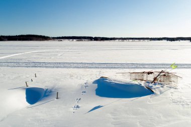 Balıkçılık malzemeleri kış için kıyıya bırakıldı. Kar neredeyse onları kapladı..