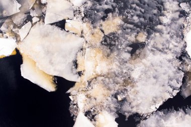 Soğuk bir kış gününde buz yavaşça nehirde yüzüyor. Nehir tamamen donmuş değil, su yüzeyinde buz parçaları var..