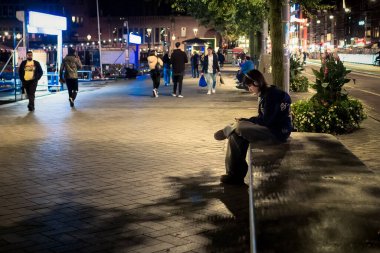 Amsterdam, Hollanda 'da akşam trafiğinin ortasında yalnız bir kız müzik dinliyor..