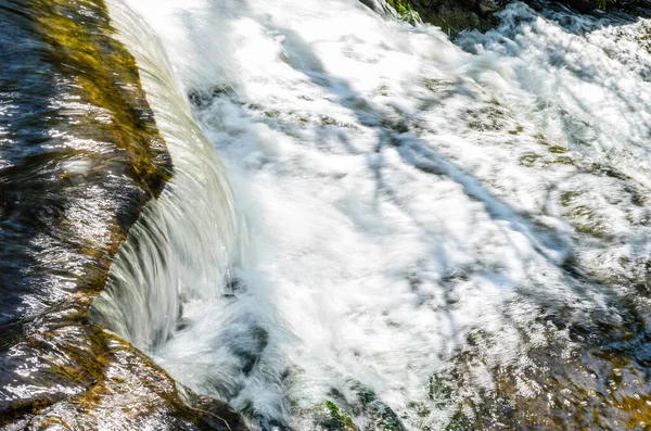 stock image Close-up of a water cascading in a stream creating frothy water.