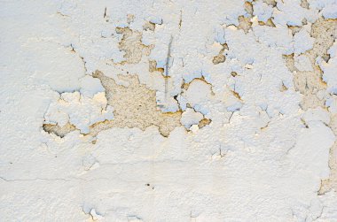Eski bir binanın dış duvarındaki beyaz kabuk soyma boyası yakın plan..