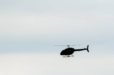Soluk mavi gökyüzüne doğru uçan tek bir helikopter.