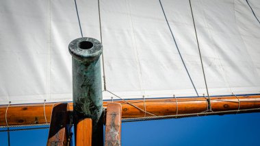 Pirinç top arka planda yelkenli ile gökyüzüne bakan Uzun Gemi