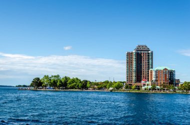 St. Lawrence Nehri 'nde mavi bir yaz gökyüzünün altındaki bir grup deniz kıyısındaki apartman dairesinin görüntüsü.