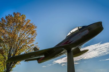 Brockville, Ontario, Kanada; Tek bir RCAF Golden Hawks savaş jeti mavi gökyüzüne ve beyaz bulutlara karşı sergileniyor..