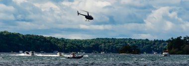Yazın St. Lawrence Nehri 'ndeki teknelerin üzerinde uçan bir helikopter manzarası