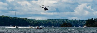 Yazın St. Lawrence nehrinde uçan bir helikopterin yan görüntüsü.