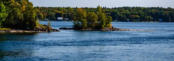 Bin Adalar arasında daha büyük bir tanesinin yanında yer alan küçük bir ağaç örtüsü etrafında St. Lawrence Nehri 'nin aktığını gösteriyor..