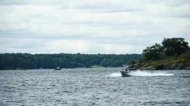 Tek sürat teknesi, St. Lawrence Nehri 'nde sağdan sola doğru hızla ilerliyor..