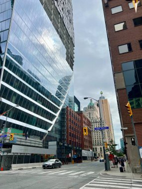 A city street view showcasing the mix of modern glass skyscrapers and historic brick buildings on Simcoe Street in downtown Toronto, Ontario, Canada. The urban scene. clipart