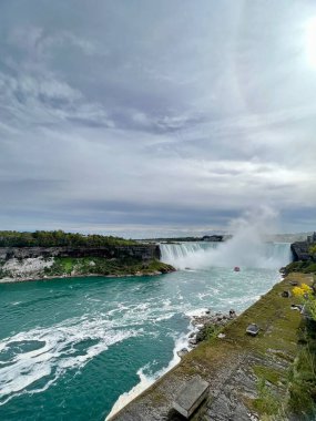 Niagara Şelaleleri 'nin panoramik manzarası. Niagara Şelaleleri 'nin geniş açılı görüntüsü, yemyeşil ve sisle çevrili güçlü şelaleleri gösteriyor.