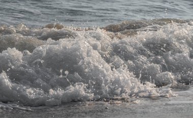 Dalgalar deniz kıyısı makrosu sıçratıyor. Yaklaş.