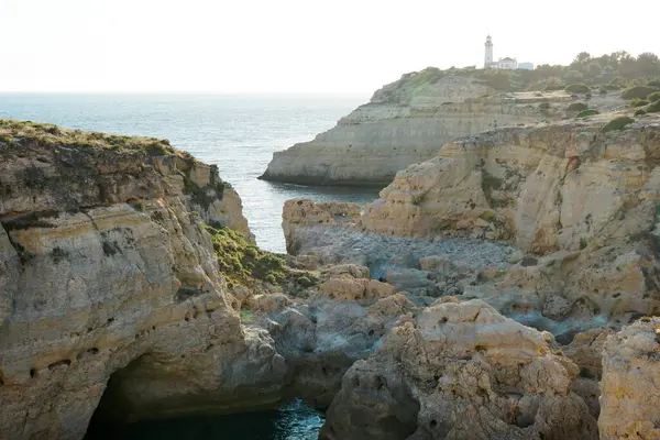 stock image The wild and scenic limestone coast of the Algarve, Portugal, with the Alfanzina Lighthouse. Between Benagil and Alfanzina.