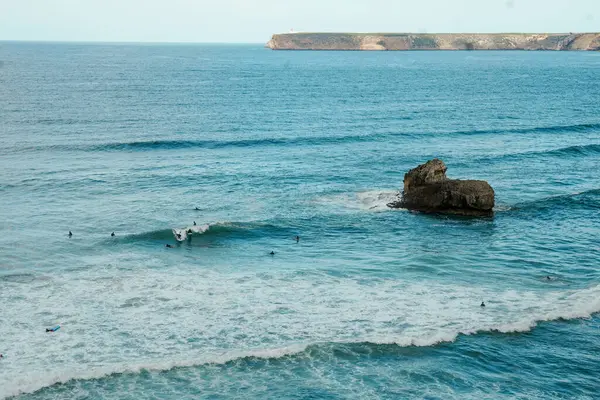 Okyanusta sörfçüler. Cape Sagres, Algarve, Portekiz 'deki Praia do Tonel (Tonel plajı) panorama manzarası. Praia Do Tonel, Alentejo, Portekiz plajı. Praia Do Tonel sahilinde okyanus dalgaları. Sagres Kalesinden Görünüm.