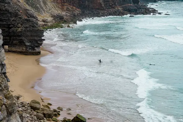Okyanusta sörfçüler. Cape Sagres, Algarve, Portekiz 'deki Praia do Tonel (Tonel plajı) panorama manzarası. Praia Do Tonel, Alentejo, Portekiz plajı. Praia Do Tonel sahilinde okyanus dalgaları. Sagres Kalesinden Görünüm.