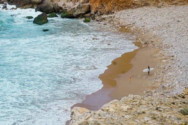 Okyanusta sörfçüler. Cape Sagres, Algarve, Portekiz 'deki Praia do Tonel (Tonel plajı) panorama manzarası. Praia Do Tonel, Alentejo, Portekiz plajı. Praia Do Tonel sahilinde okyanus dalgaları. Sagres Kalesinden Görünüm.