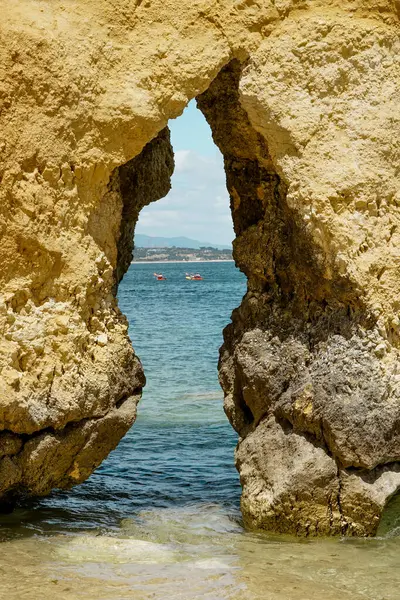 Kanoları olan insanlar. Portekiz, Lagos 'taki Ponta da Piedade' den Rocky Clifs. Okyanus güzel manzara kayalıkları ve mağaralar