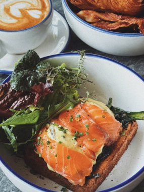 Popüler bir kahvaltı. Yumurta, avokado tostu, somonlu tost, kahve, salata. Bali 'de dayanıklı yiyecekler.
