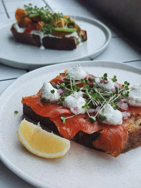 Popüler bir kahvaltı. Yumurta, avokado tostu, somonlu tost, kahve, salata. Bali 'de dayanıklı yiyecekler.