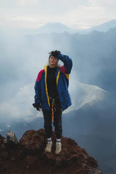 Ruang yanardağının tepesinde manzaralı dağ manzaralı güzel bir gezgin kız. Volkan krateri.