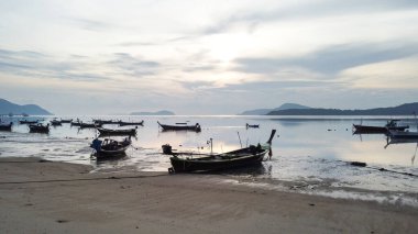Geleneksel uzun kuyruklu teknelerle akan tropikal kıyıların güzel manzarası, Phuket Adası, Tayland. Gün doğumu. Sabah ışığı