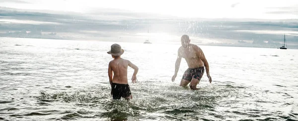 快乐的父亲在水里和小儿子一起玩 一起泼洒 一起玩乐 爸爸和孩子在海滩上家庭假期 夏天的感觉 — 图库照片