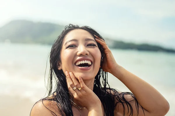 美丽的年轻亚洲女人的画像 带着惊人的灿烂笑容 头发湿透的女孩在海滩上享受着阳光灿烂的日子 快乐假日生活的概念 真实的人的情感 旅行人员 — 图库照片