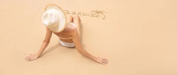 楽園の世界と砂の上のヤシの木と砂浜でリラックスした白い帽子の美しい女性のバックビュー 夏休み 観光の概念 スペースのコピー — ストック写真
