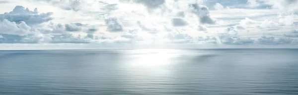 Photo of a horizon where sky with clouds and blue sea surface meet. Seascape. Background. Ocean.