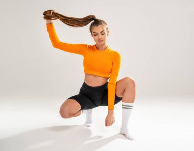 Fit woman, sportswoman posing on studio background, full length photo. Fashionable sporty clothes. Copy space. Healthy lifestyle.