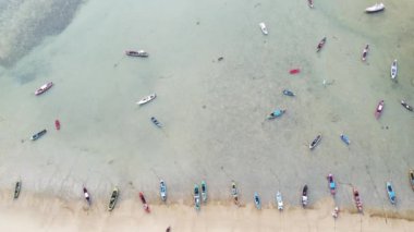 Aerial drone view of tropical coast with long tail fishing boats. Phuket island, Thailand. Beautiful sea surface.