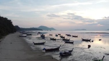 Aerial drone view of tropical coast with long tail fishing boats. Phuket island, Thailand. Beautiful sea surface.